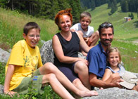 Familie lächelt in die Kamera vor Bergpanorama